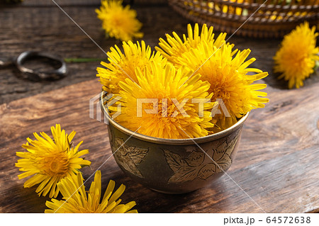 Closeup of dandelion flowers in a bowl 64572638