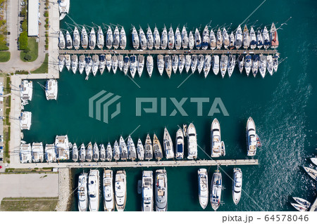 Croatia, marina Kastela, Drone view point on moored in an equal row sailboats, participant of a sailing regatta, piers, a lot of boats, mountains is on background, piers 64578046