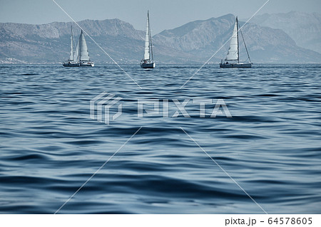 Beautiful sea landscape with sailboats, the race of sailboats on the horizon, a regatta, a Intense competition, bright colors, island with windmills are on background Beautiful sea landscape with sailboats, the race of sailboats on the horizon, a regatta, a Intense competition, bright colors, island with windmills are on background 64578605
