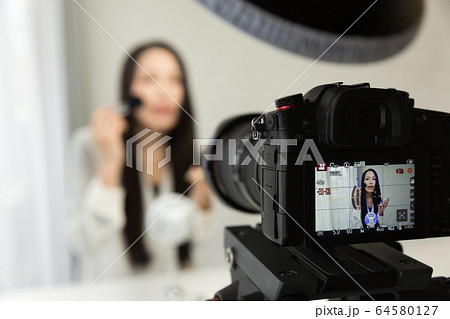 一眼レフカメラで動画を撮影する女性 一眼レフカメラで動画を撮影する女性 64580127