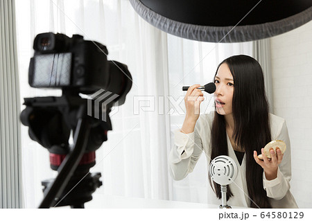 一眼レフカメラで動画を撮影する女性 64580129