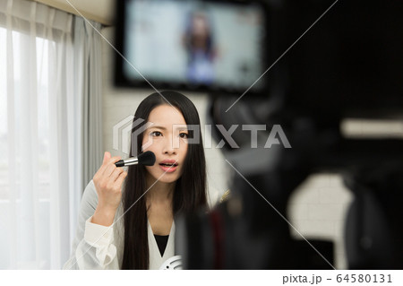 一眼レフカメラで動画を撮影する女性 64580131