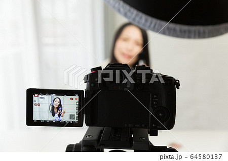 一眼レフカメラで動画を撮影する女性 一眼レフカメラで動画を撮影する女性 64580137