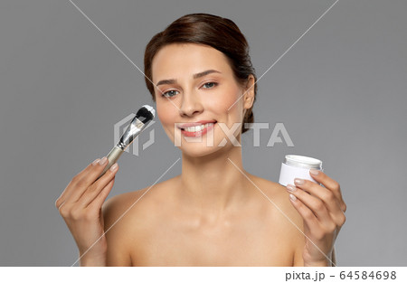 beautiful young woman with facial mask and brush 64584698