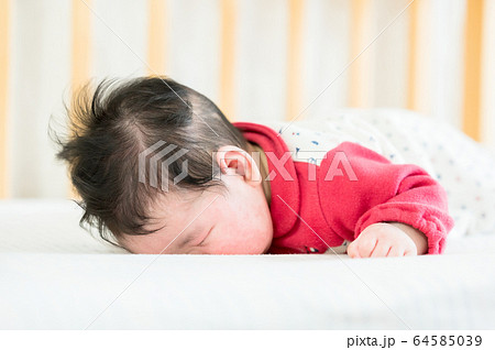 うつ伏せ寝する赤ちゃんの写真素材