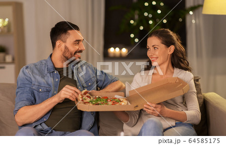 happy couple eating takeaway pizza at home happy couple eating takeaway pizza at home 64585175