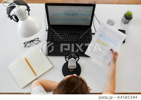 woman with microphone recording podcast at studio 64585394