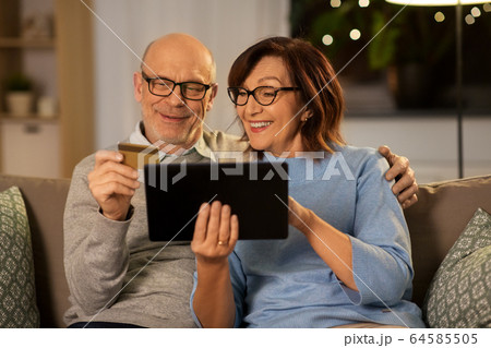 happy senior couple with tablet pc and credit card 64585505