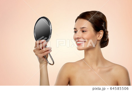 beautiful young woman looking to mirror 64585506