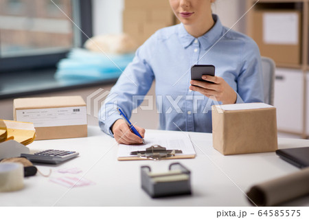woman with smartphone and clipboard at post office 64585575