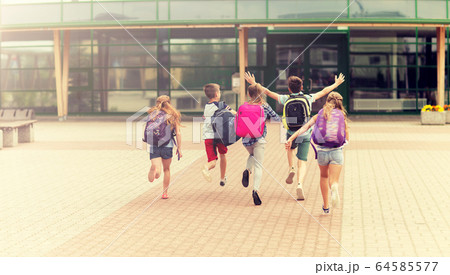 group of happy elementary school students running group of happy elementary school students running 64585577