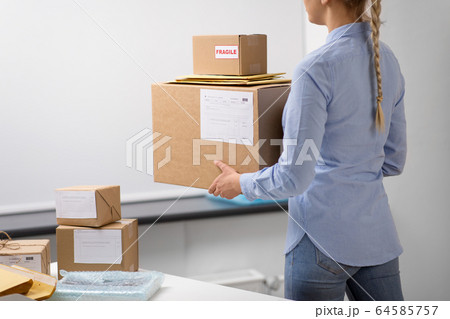 woman walking with parcels at post office 64585757