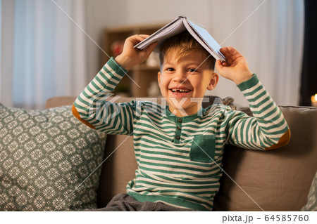 happy little boy with book having fun at home 64585760