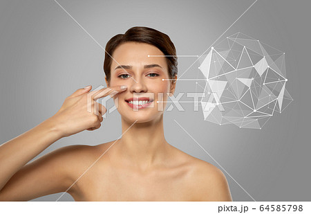 beautiful woman pointing finger to face skin 64585798