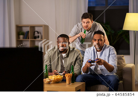 happy friends playing video games at home at night happy friends playing video games at home at night 64585854