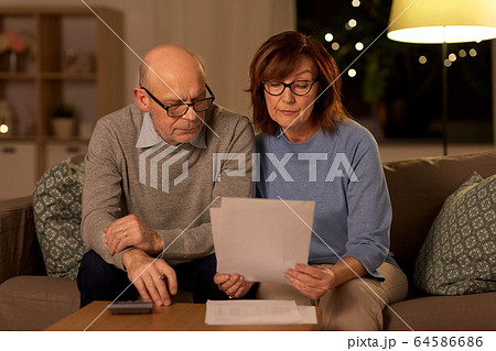 senior couple with papers and calculator at home 64586686