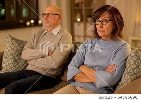 unhappy senior couple sitting on sofa at home 64586690