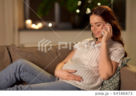 happy pregnant woman calling on smartphone at home 64586873