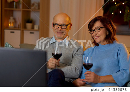 happy senior couple drink red wine and watch tv 64586878