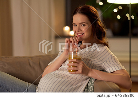 happy pregnant woman drinking juice at home happy pregnant woman drinking juice at home 64586880