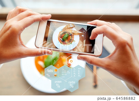 hands with phone and food nutritional value chart 64586882