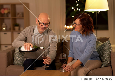 happy senior couple drinking red wine at home 64587035