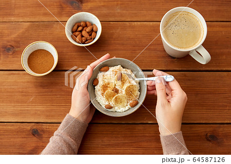 hands with oatmeal breakfast and cup of coffee hands with oatmeal breakfast and cup of coffee 64587126