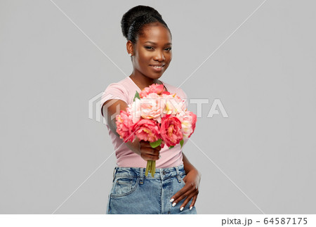 happy african american woman with bunch of flowers 64587175