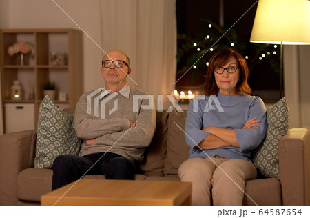 unhappy senior couple sitting on sofa at home unhappy senior couple sitting on sofa at home 64587654