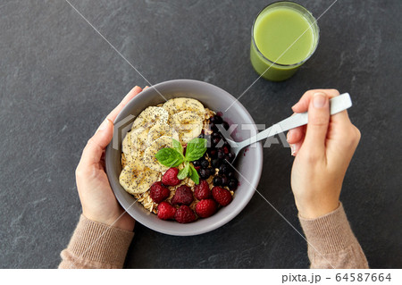 hands of woman eating cereal breakfast with spoon hands of woman eating cereal breakfast with spoon 64587664