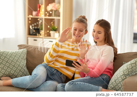 girls having video call on smartphone at home 64587737