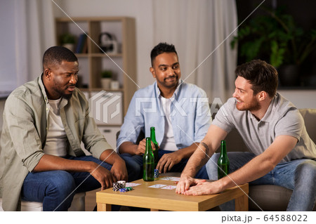 happy male friends playing cards at home at night happy male friends playing cards at home at night 64588022