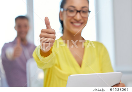 happy young woman with tablet pc showing thumbs up 64588065