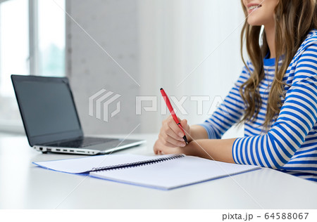 student girl with exercise book, pen and laptop 64588067