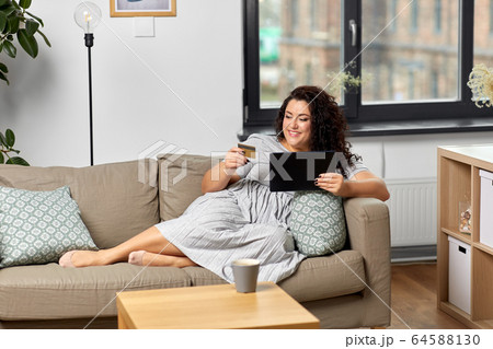 woman with tablet pc and credit card at home 64588130