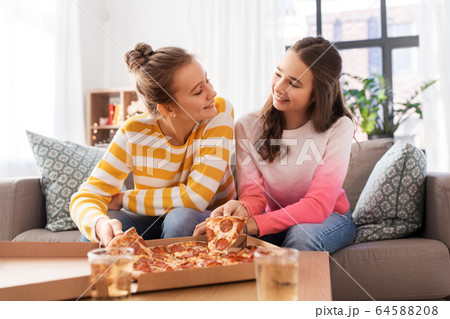 happy teenage girls eating takeaway pizza at home happy teenage girls eating takeaway pizza at home 64588208