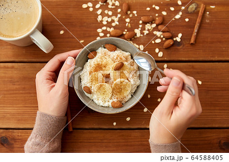 hands with oatmeal breakfast and cup of coffee hands with oatmeal breakfast and cup of coffee 64588405