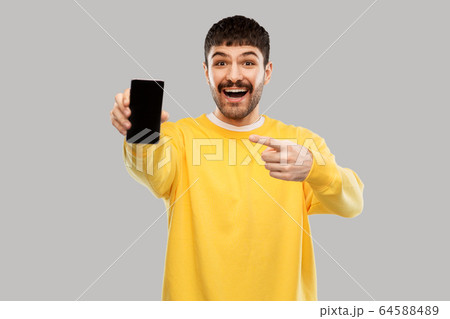 happy smiling young man showing smartphone happy smiling young man showing smartphone 64588489