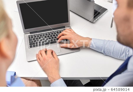 close up of businesspeople with laptop at office 64589014