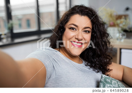 happy smiling young woman taking selfie at home happy smiling young woman taking selfie at home 64589028