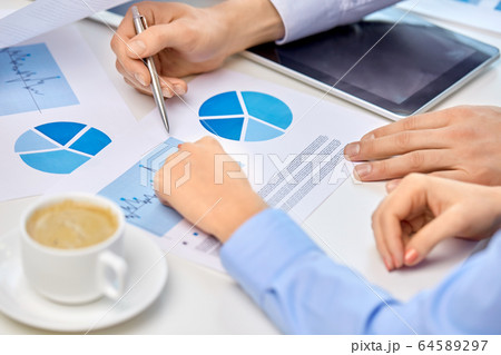 business team hands with pens and charts at office business team hands with pens and charts at office 64589297