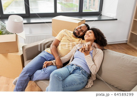 happy couple with boxes moving to new home 64589299
