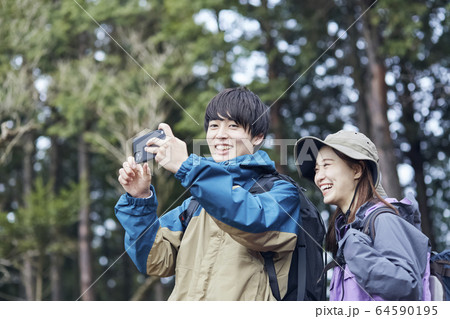 山で写真を撮るカップル 山で写真を撮るカップル 64590195