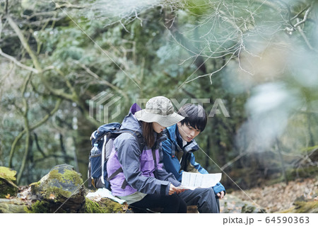 登山で地図を見るカップル 64590363