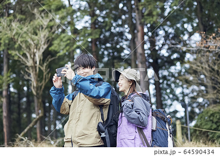 山で写真を撮るカップル 64590434
