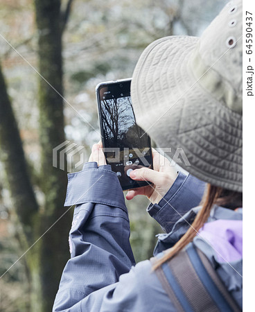 山で写真を撮る女性 山で写真を撮る女性 64590437