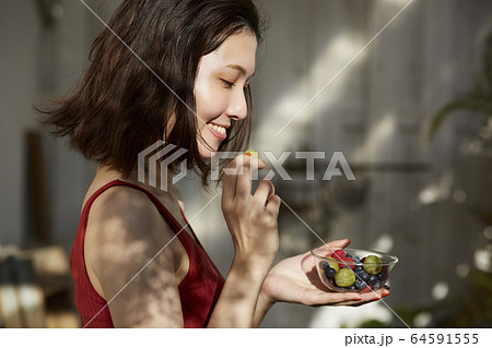 フルーツを食べる女性 64591555