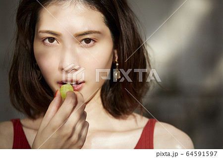 フルーツを食べる女性 64591597