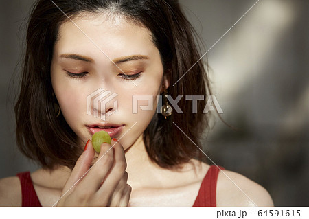 フルーツを食べる女性 64591615