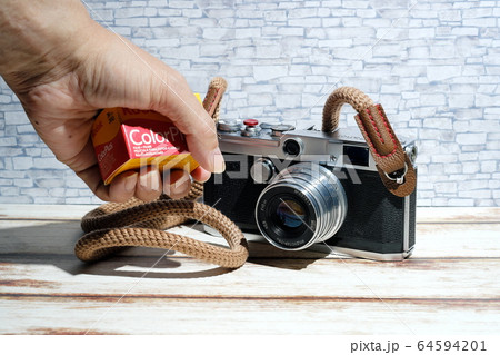 フィルムを持つ手とクラシックカメラ 64594201